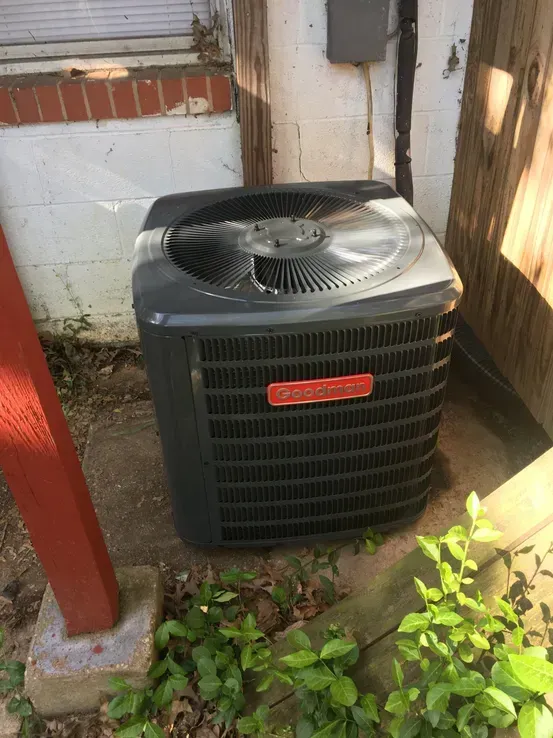 An air conditioner is sitting on the side of a building.