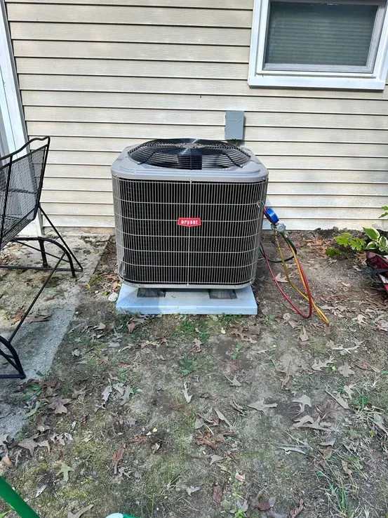 An air conditioner is sitting on the side of a house.