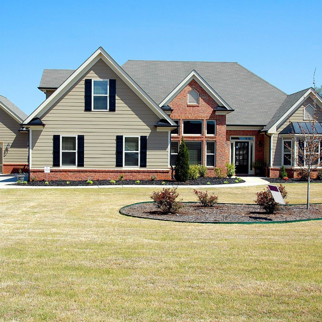 A large house with a lot of windows and black shutters