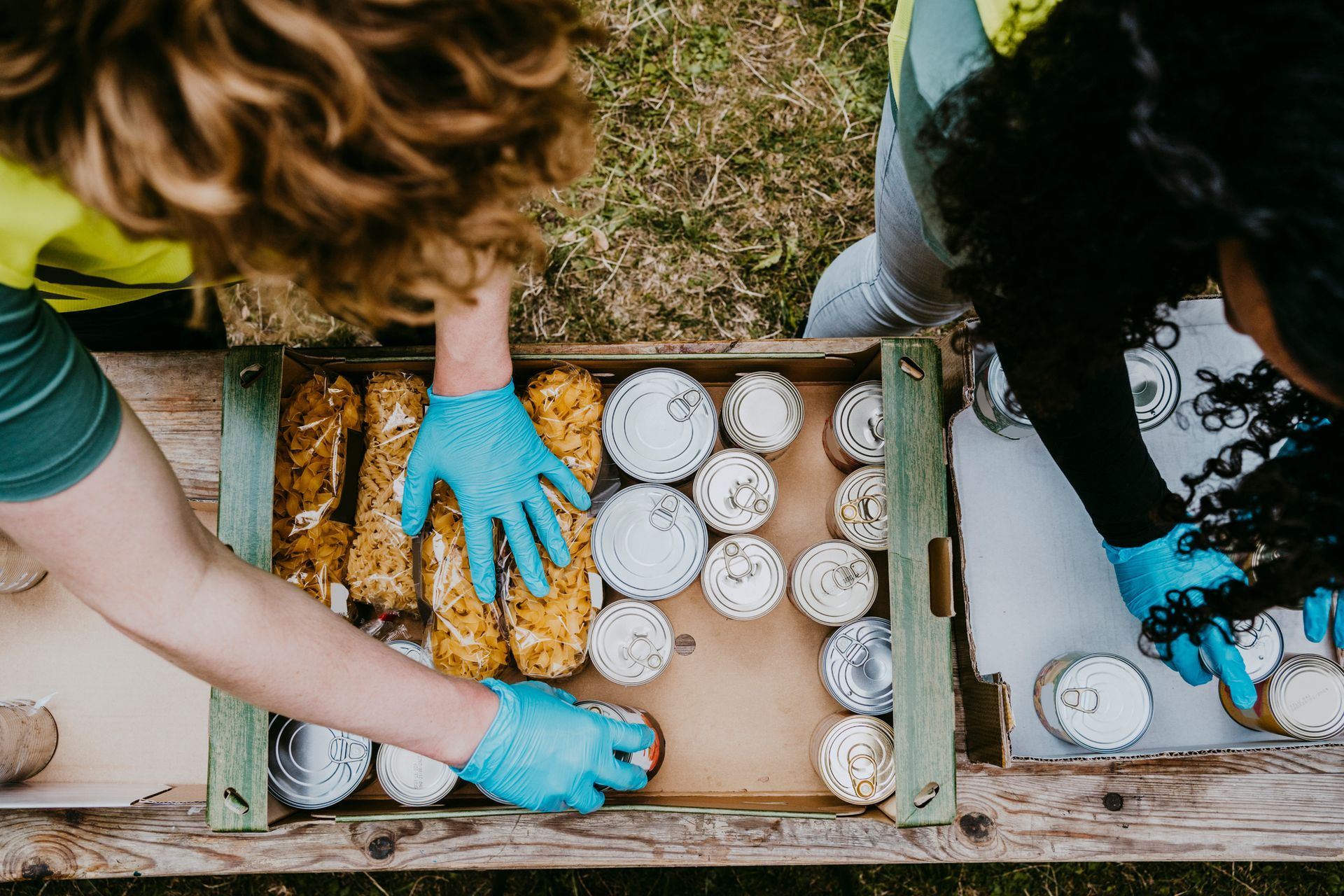 A man and a woman are putting food in a box.