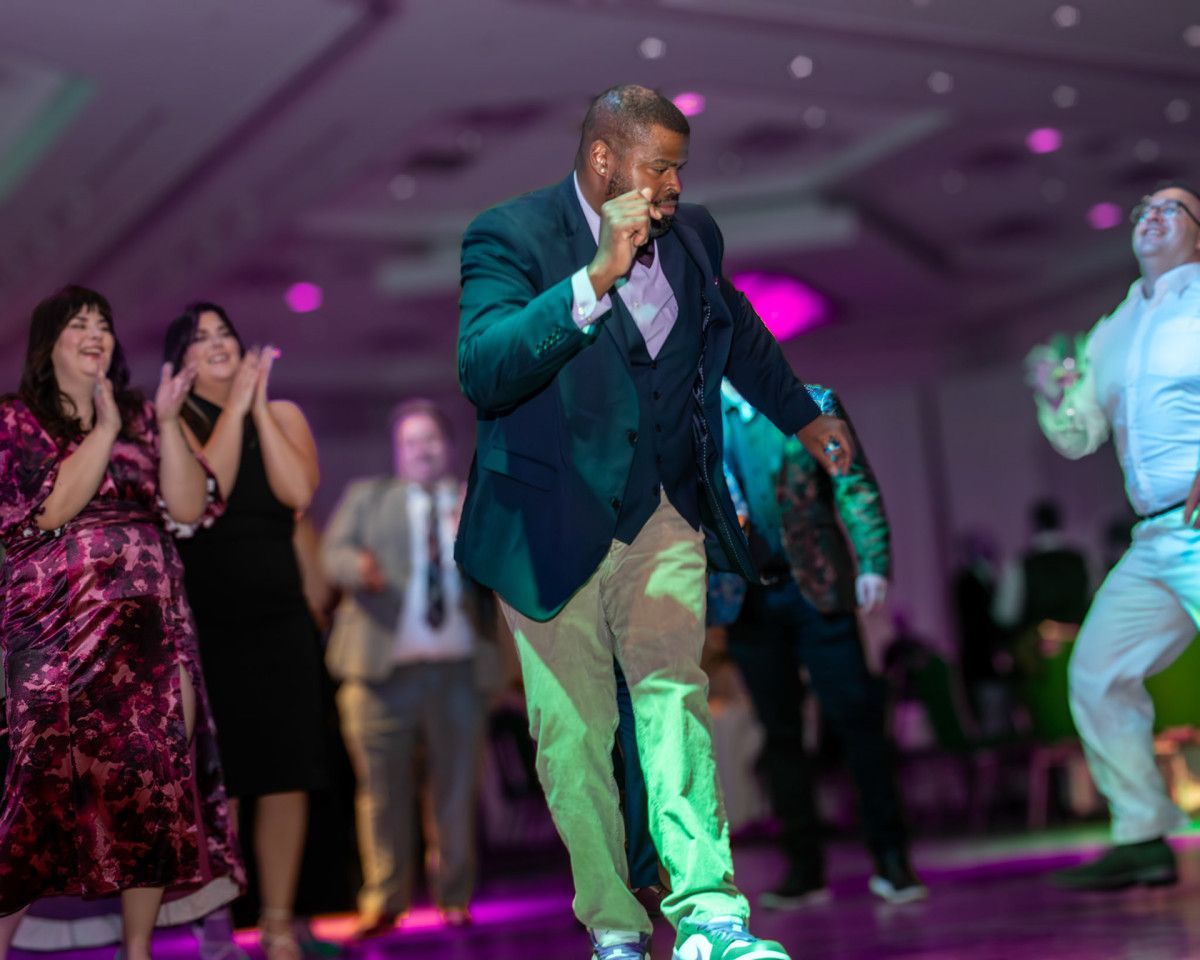 A crowd of people are raising their arms in the air at a concert.