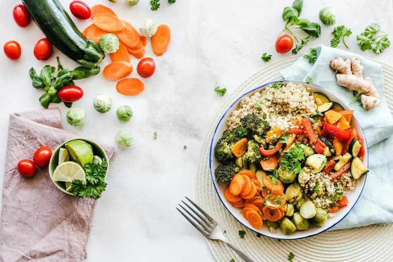 A plate of food with vegetables and rice on a table.