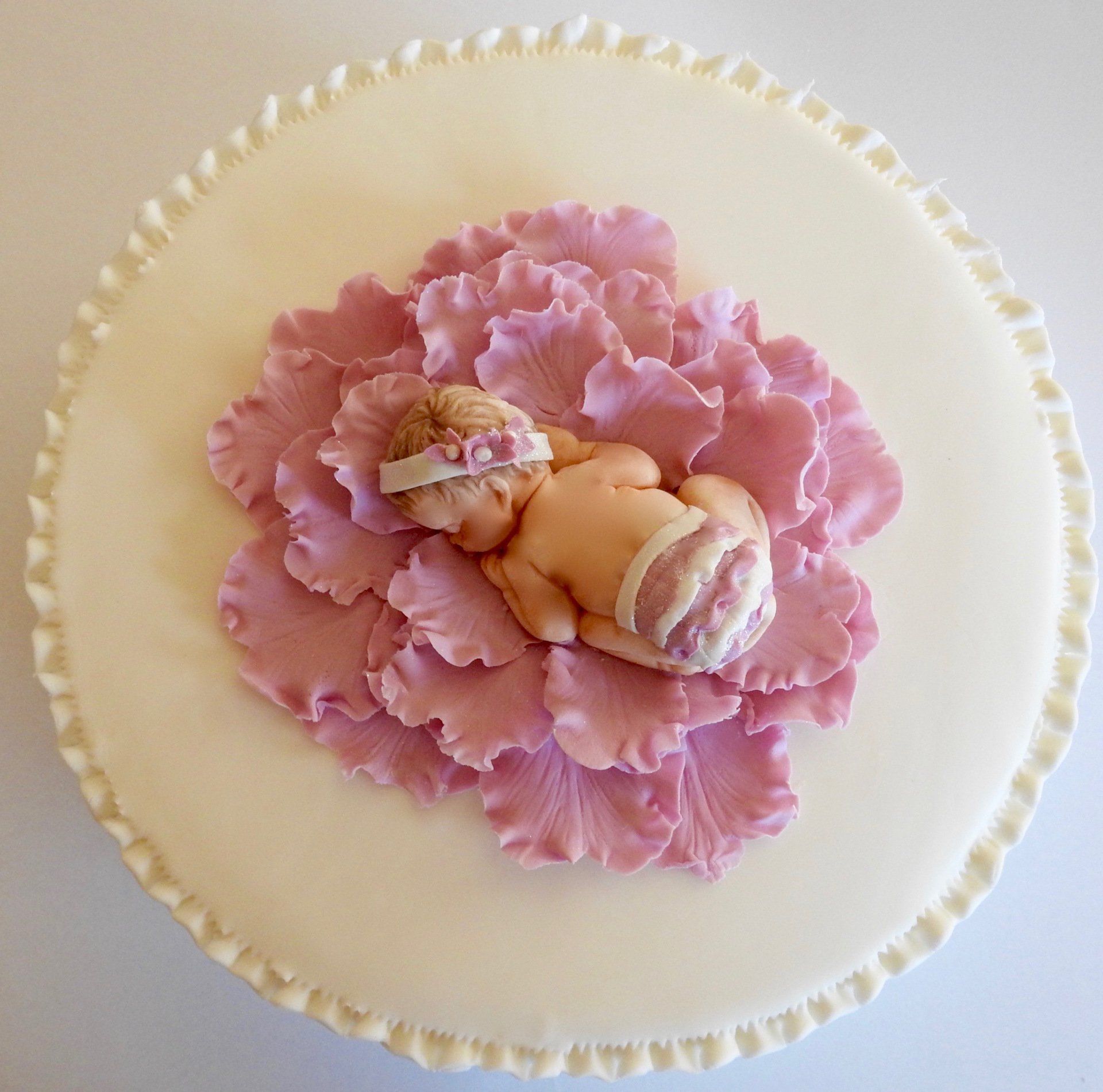 Cute Baby Girl Cake. Baby girl sleeping in a pink flower.