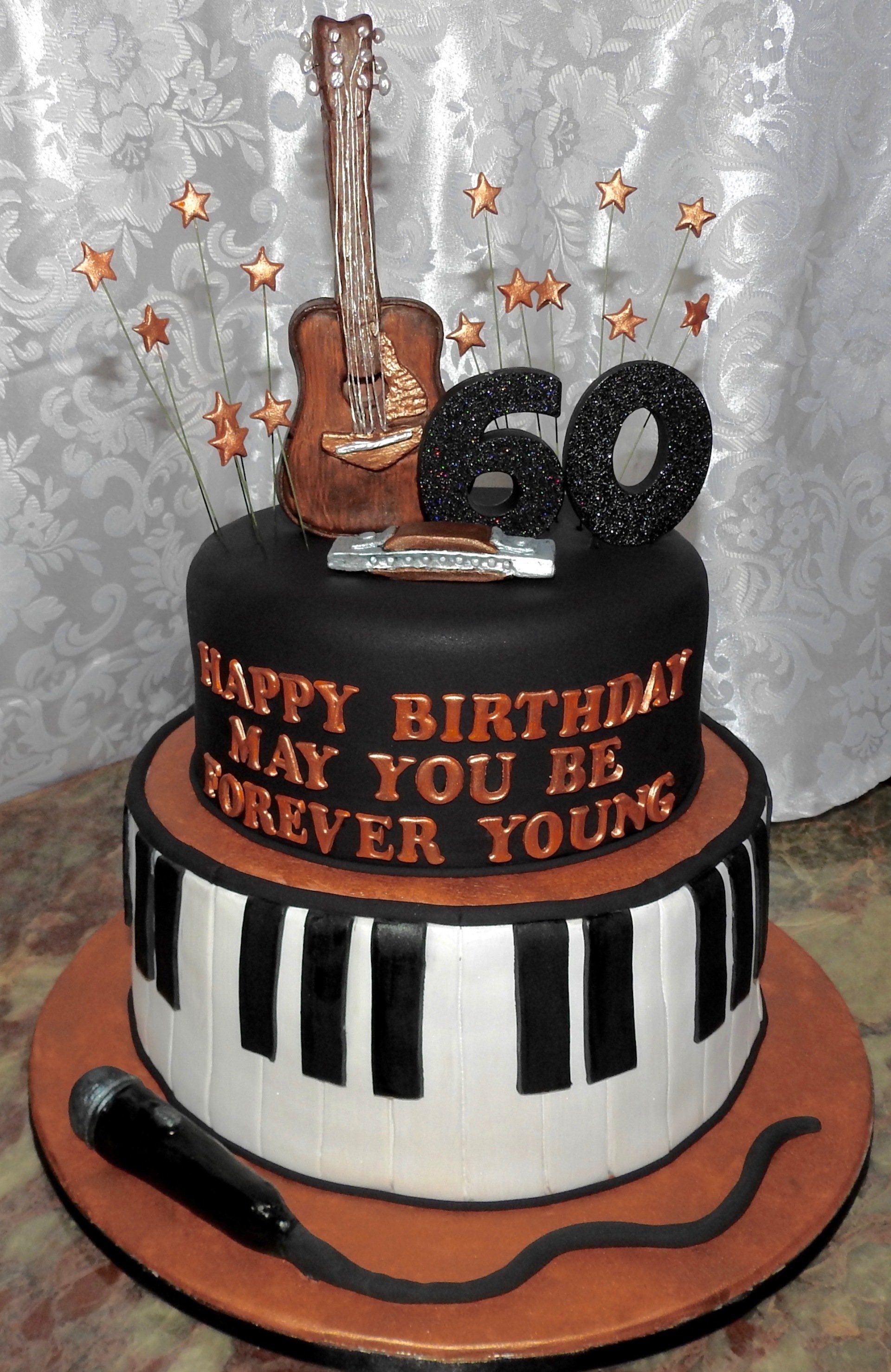 2 tier music themed cake in black white and copper with microphone, harmonica, guitar and piano.