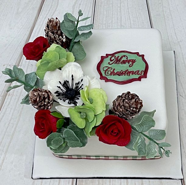 Merry Christmas Cake With Sugar Eucalyptus, Fondant Pine Cones, Sugar Anemone Flower, Fondant Green Hydrangeas and Red Sugar Roses