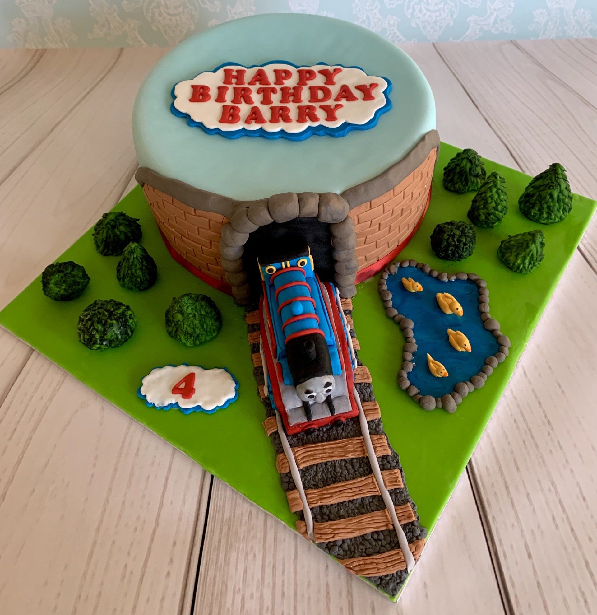 4th Boys Birthday Cake Train coming through tunnel with trees, grass and a duck pond.  Top view