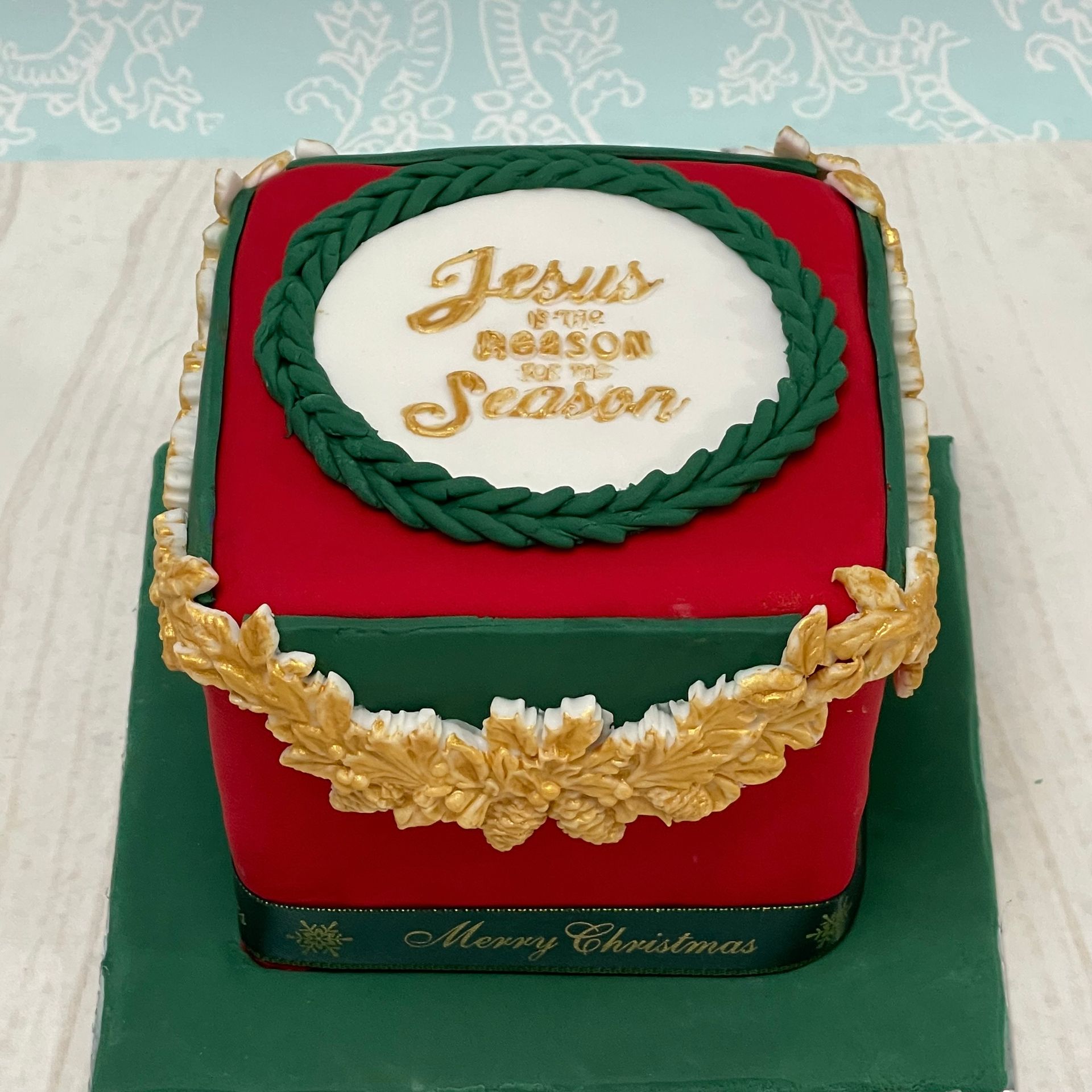 Christmas cake with a red green and gold theme and the words 