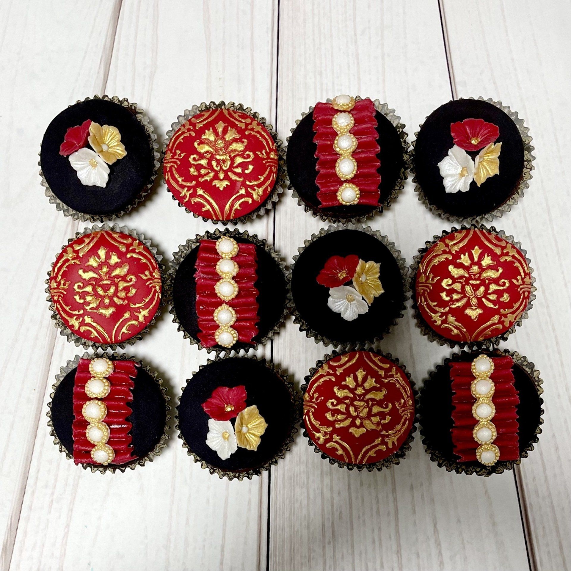 Elegant Black, Red and Gold cupcakes with fondant pearl accents.