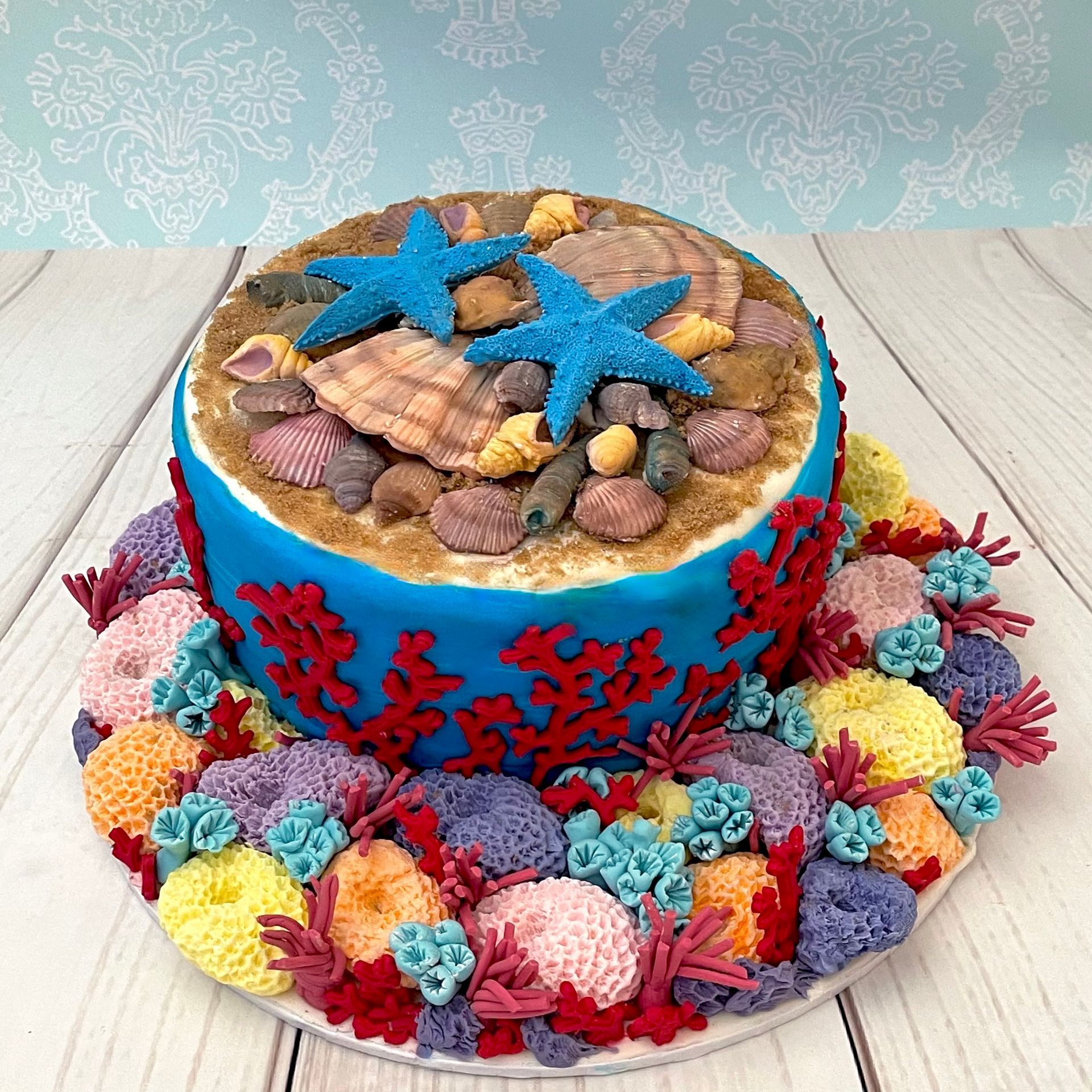 Birthday cake with handmade fondant corals and fondant shells,