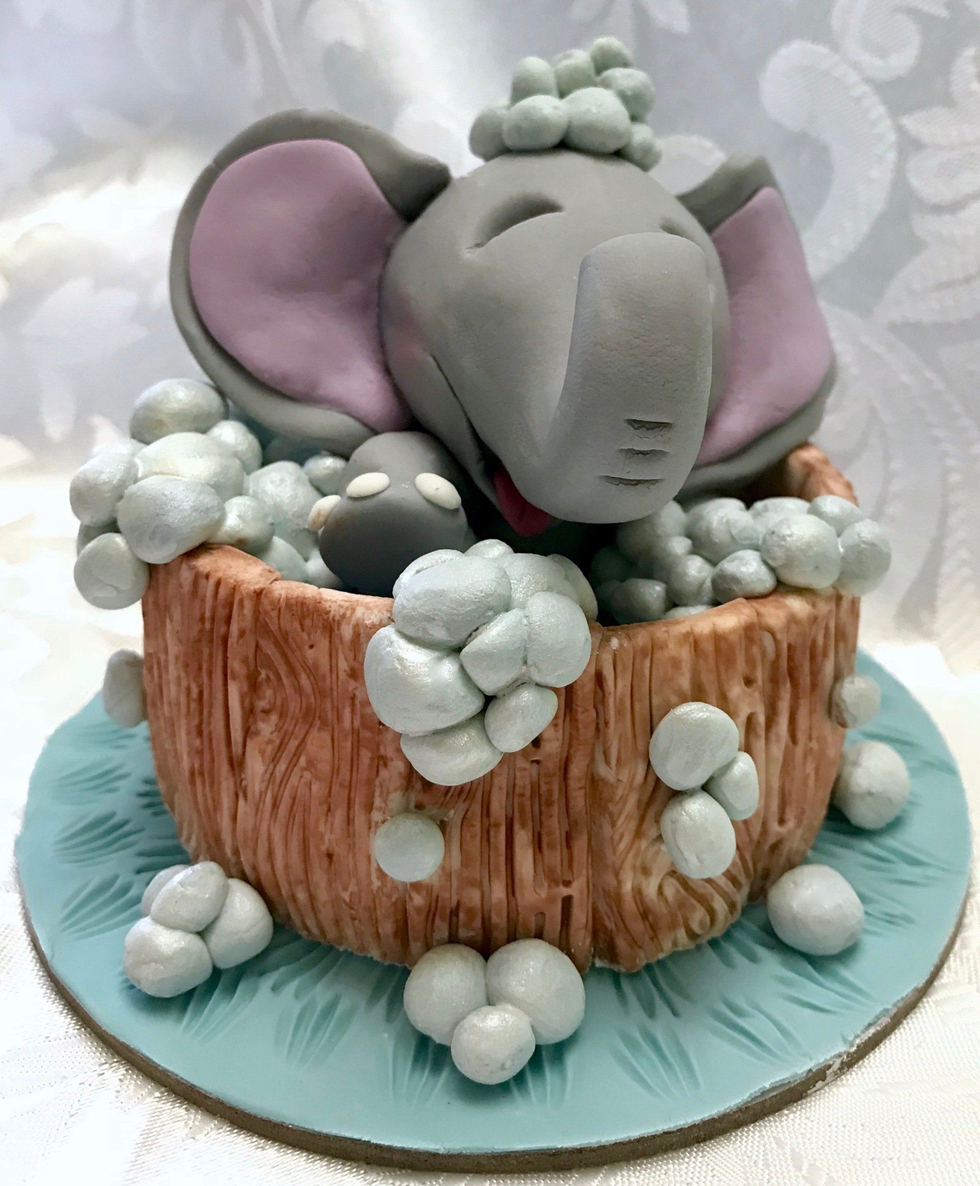 Cute Elephant splashing in a tub cake topper.
