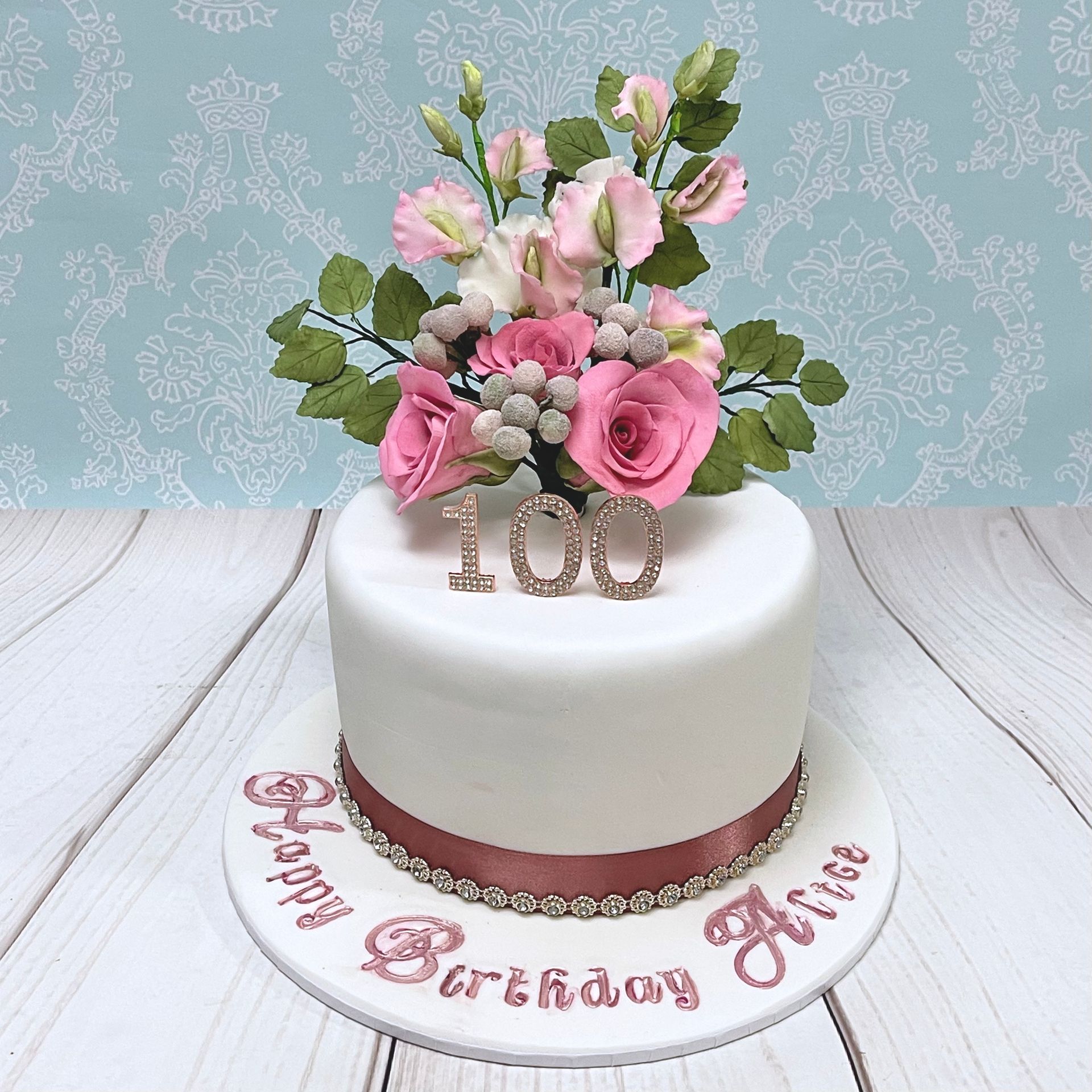 Elegant 100th Birthday Cake Covered in Fondant with Diamante topper and trim, Handmade Pink Sugar Roses, Sugar Leaves, Sugar Brunia Berries and Sugar Sweet Peas.