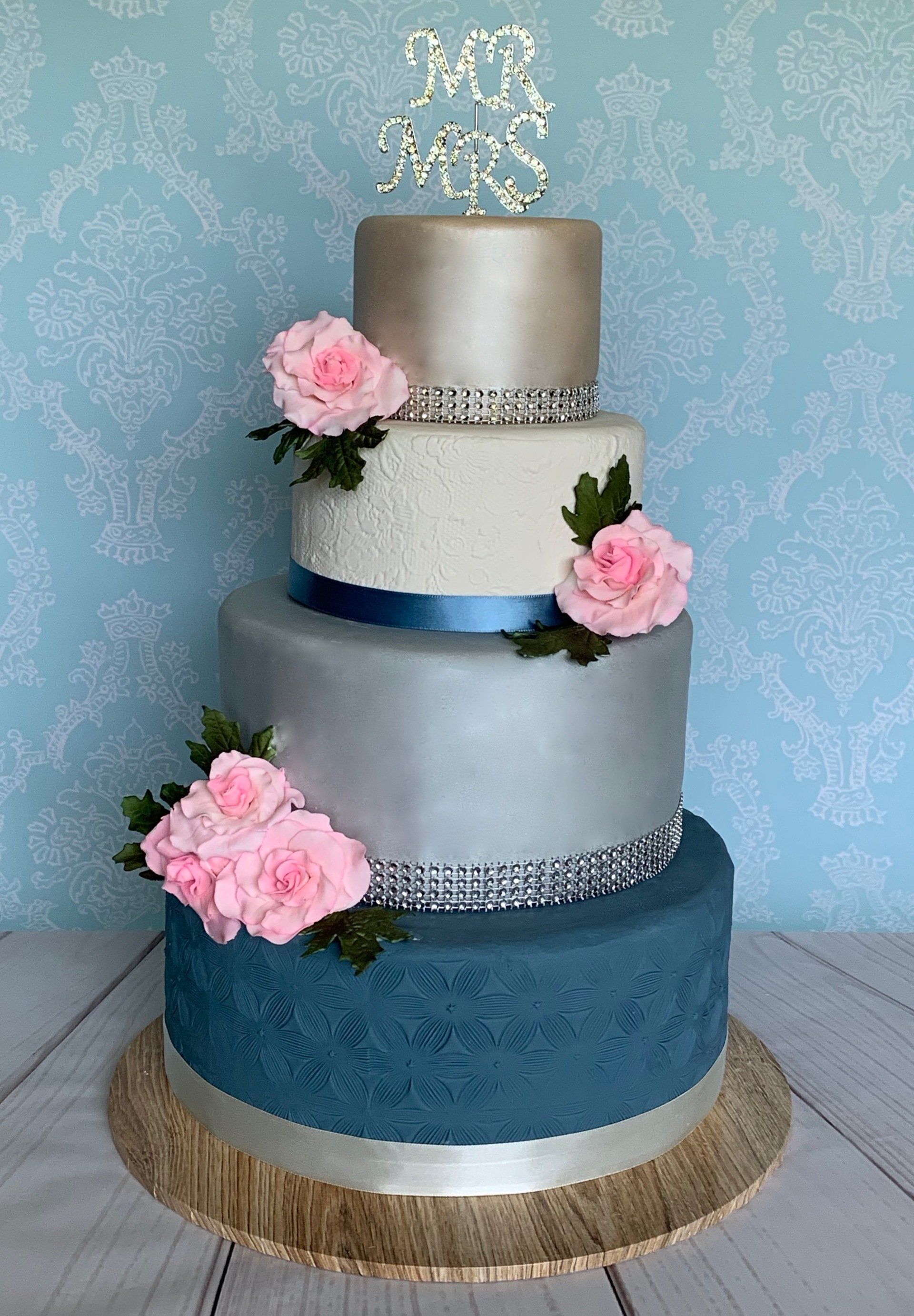 4 tiered pearl and textured Wedding Cake. Pink sugar roses and diamante Mr & Mrs topper