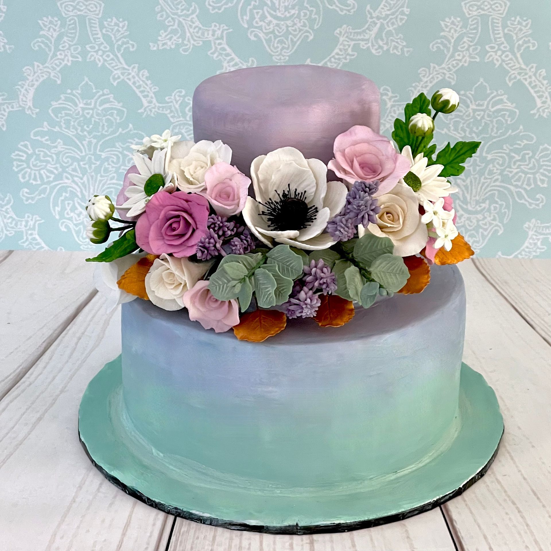 Purple, Blue And Aqua ombre tiered cake with hand made sugar flowers.