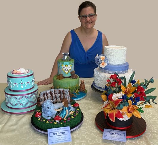 Owner of Julianne's Specialty Cakes with a display of her cakes.