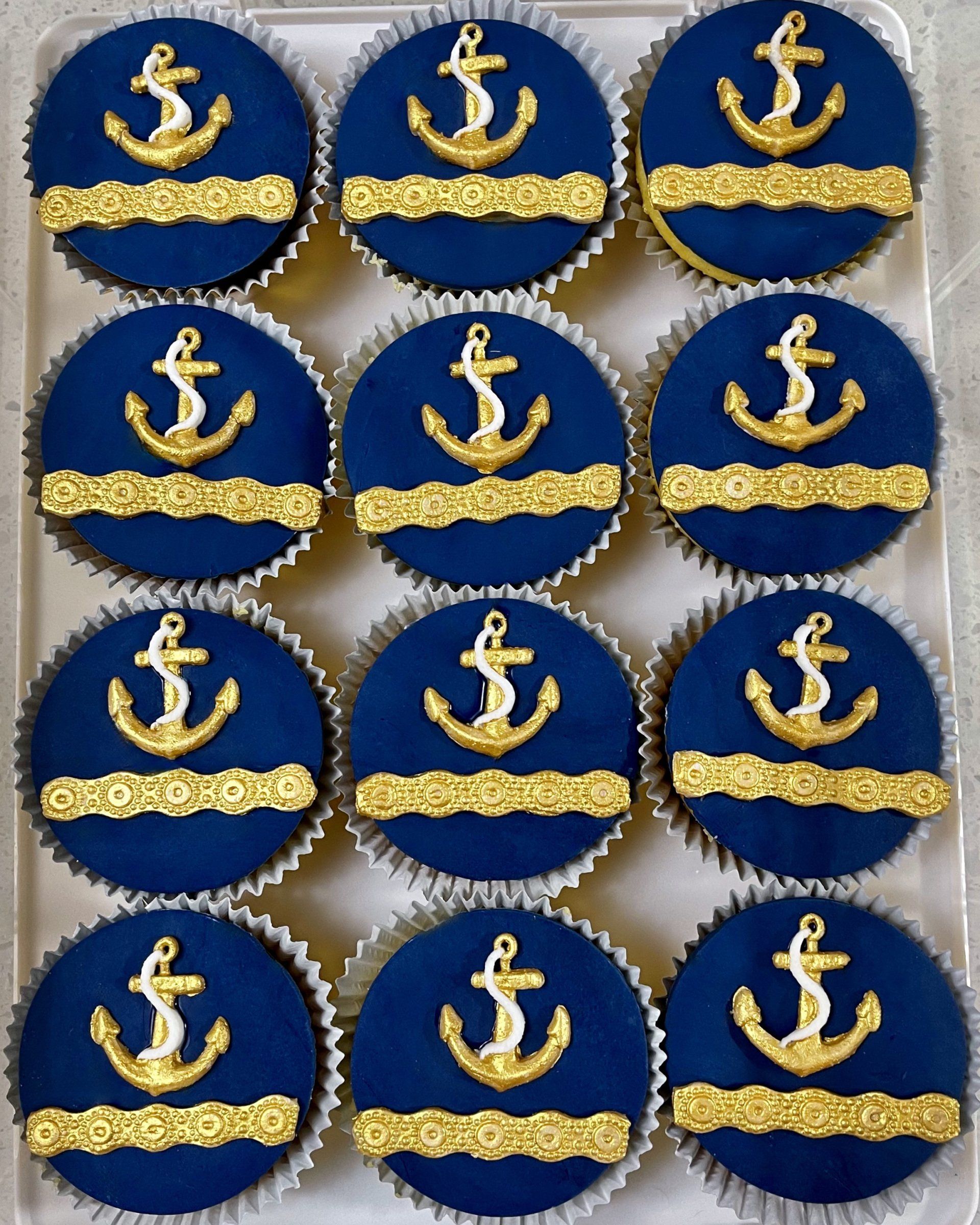 Natical Themed Cupcakes with Navy fondant and White and Gold Fondant Anchors decorations.