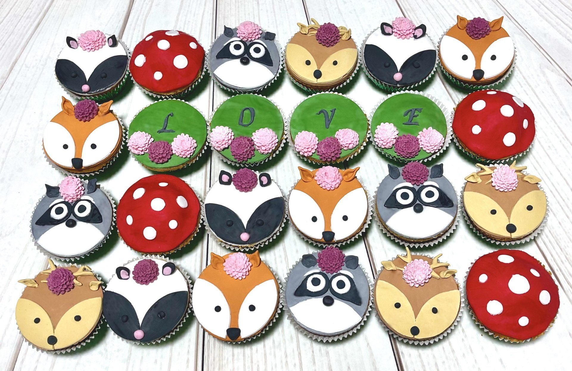 Woodland Animal Themed Cupcakes. With Fondant Deer, Badger, Racoon, and Fox Animal faces and Fondant Flower and Enchanted Mushroom Tops