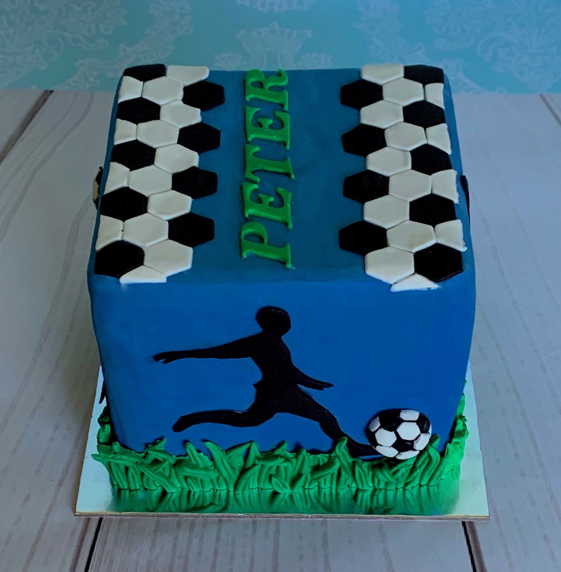 Soccer themed cake with black silhouettes, 3d moulded grass and soccer balls. Side 2.