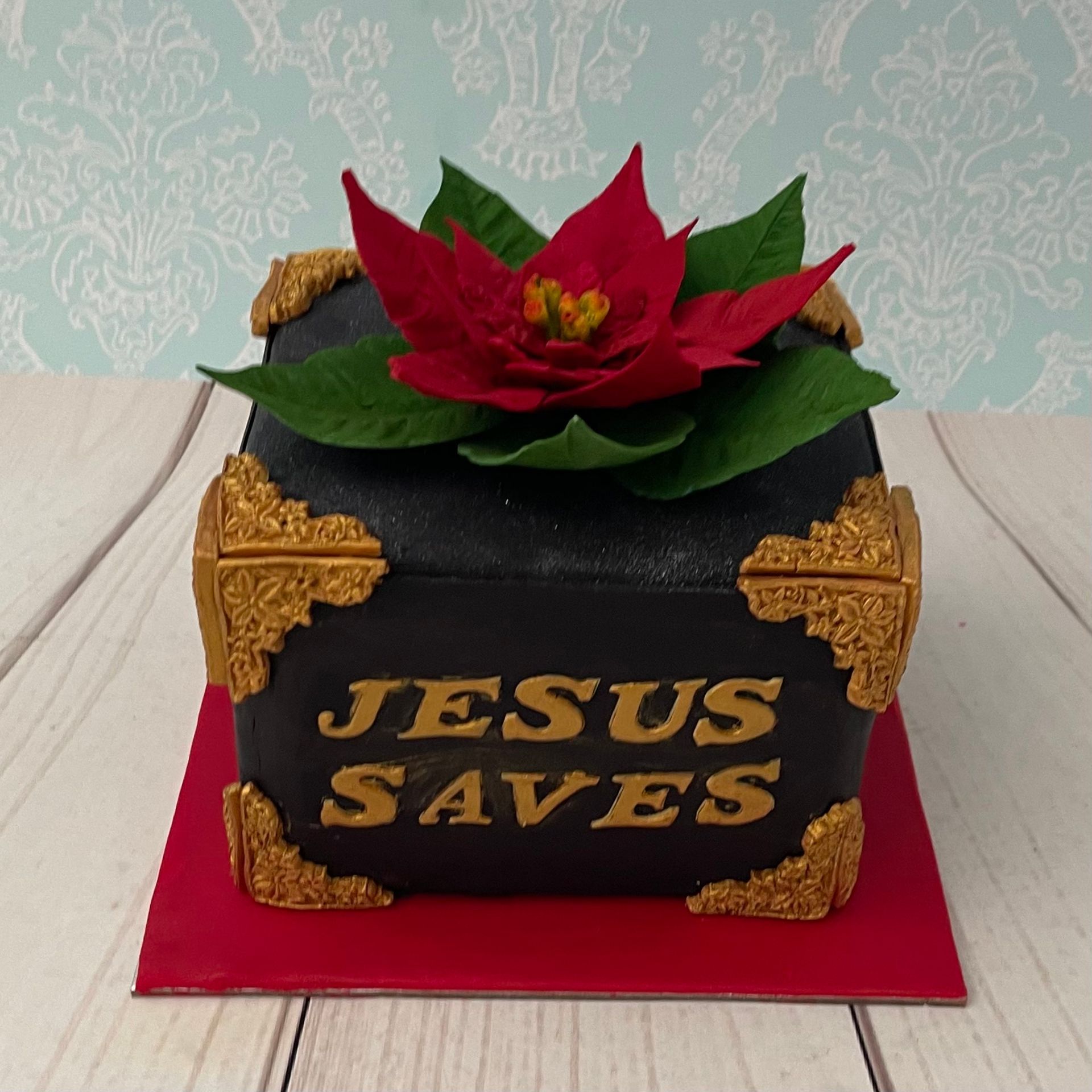 Christmas Cake with handmade sugar poinsettia fancy gold fondant border and with the words Jesus Saves in Gold 