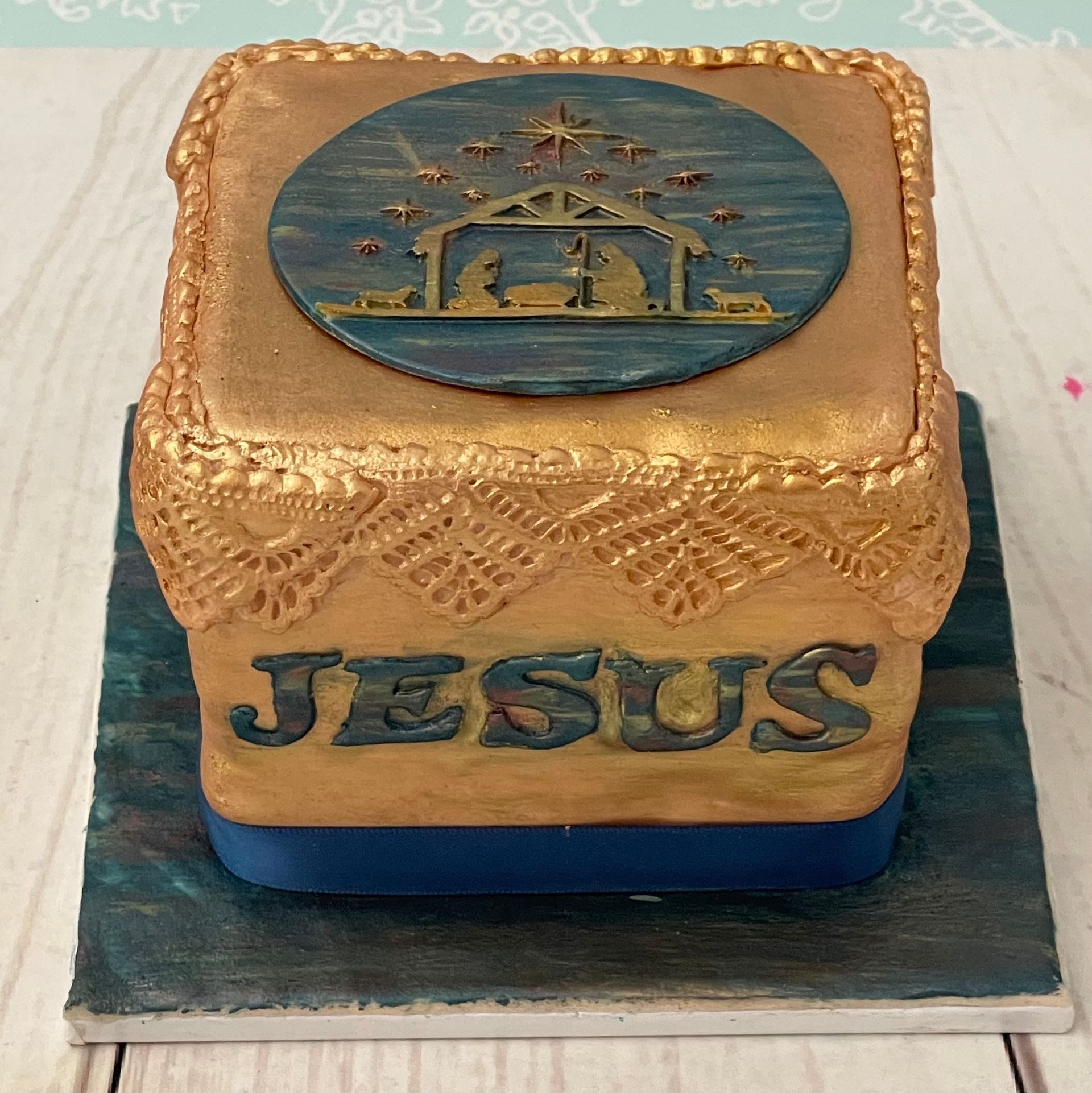 Christmas Cake with Nativity decorations and the word Jesus in blues and golds. 