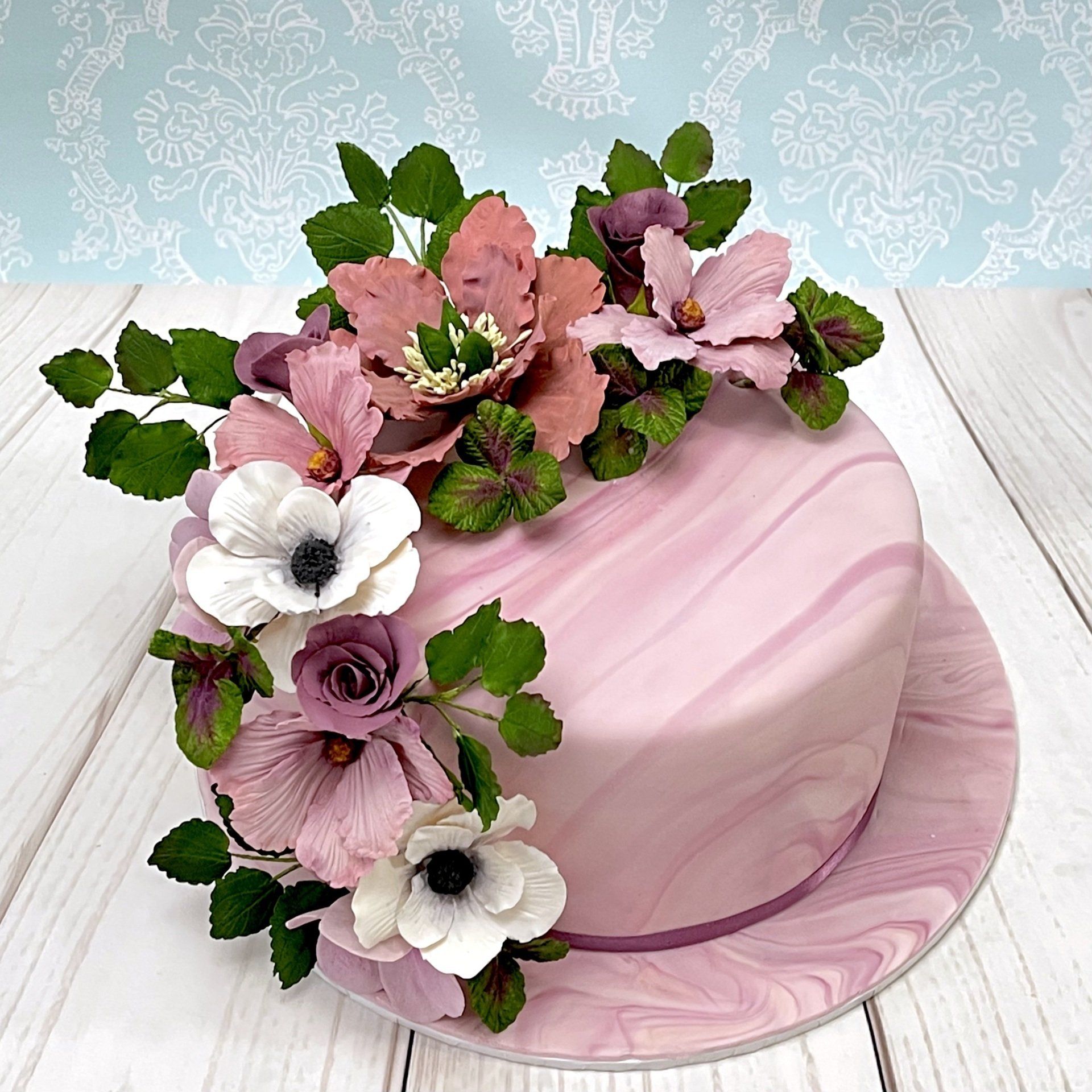 Pretty Birthday Cake with a cascading arrangement of Blush coloured Sugar flowers, Sugar leaves and soft blush marbled fondant.