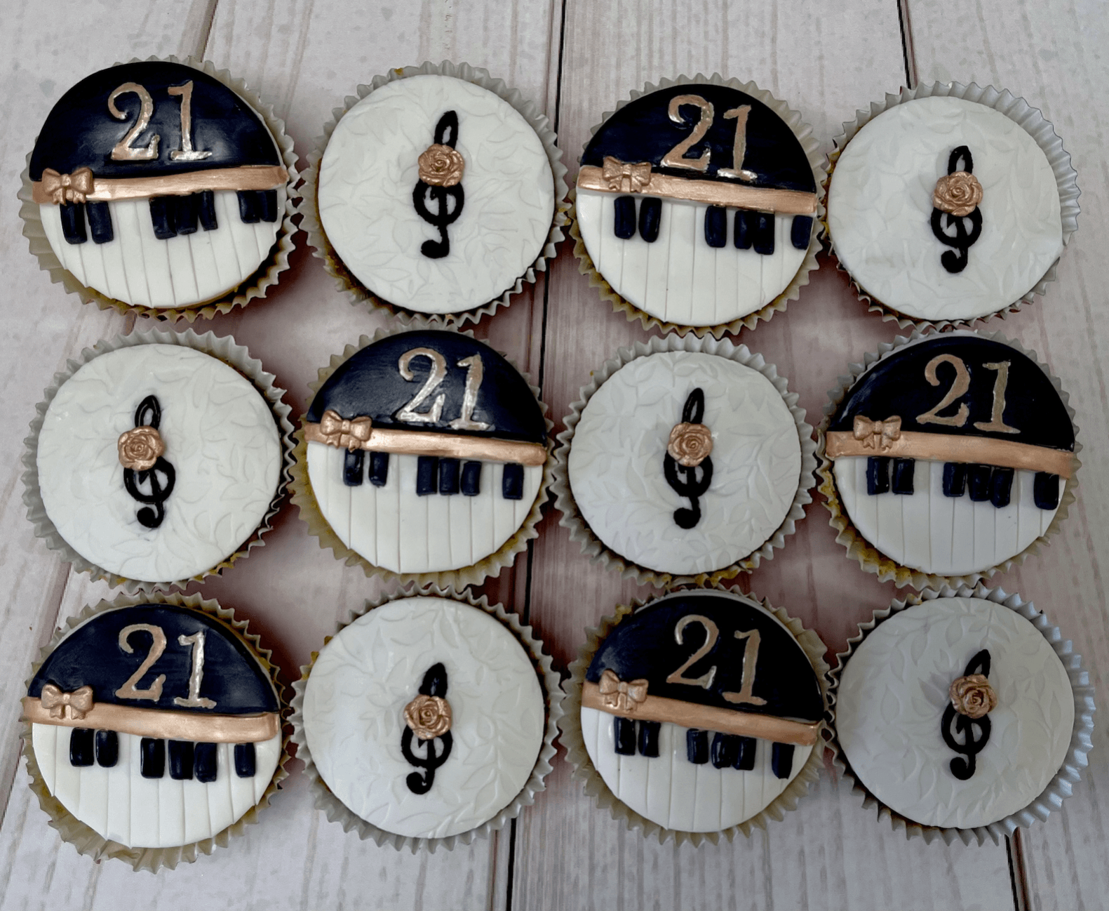 Music Themed Cupcakes  a 21st Birthday. Rose Gold, Black and White,  Colour Scheme. Half with a fondant Trebel Clef and Small Rose, the other half with a Fondant Piano and 21