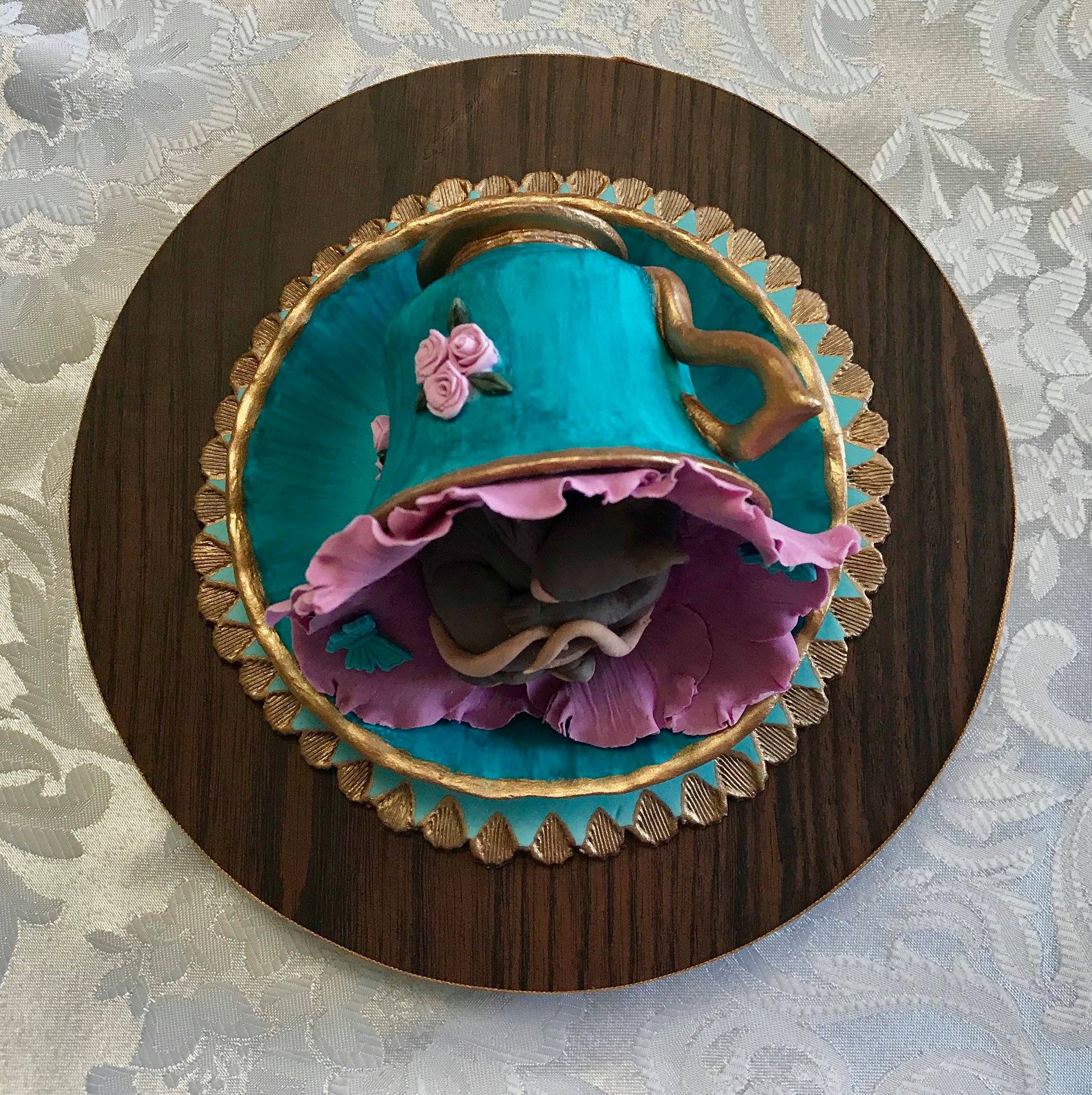 Cake topper of two very cute mice sleeping in a flower inside an ornate teacup.all made from sugar