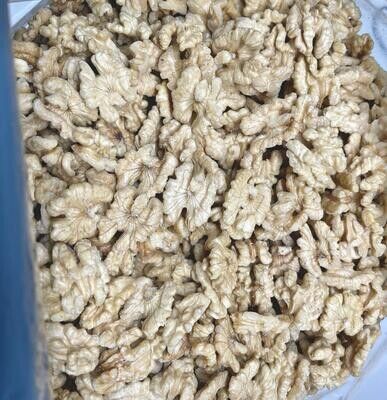 Un cuenco lleno de nueces sin cáscara, de color beige y con textura, visto desde arriba.