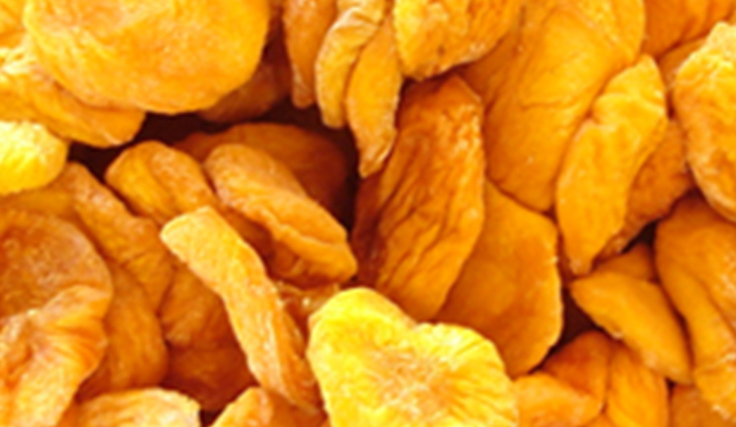 Primer plano de rodajas de fruta seca de color naranja brillante apiladas juntas.
