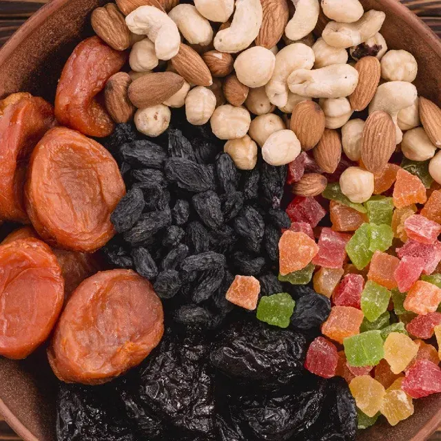 Surtido de frutos secos, pasas y coloridas frutas confitadas en una vista aérea de cerca.