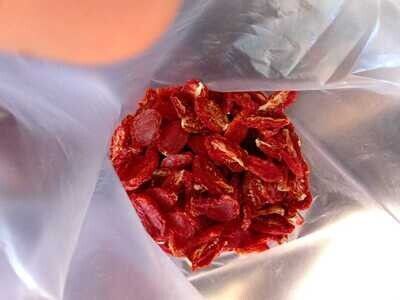 Bolsa de plástico llena de trozos de carne roja seca y huesos.