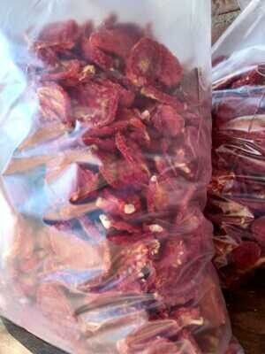 Bolsa de plástico llena de trozos de carne roja seca y huesos.