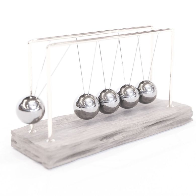 Newton's cradle toy with five silver metal spheres suspended by strings on a wooden base.