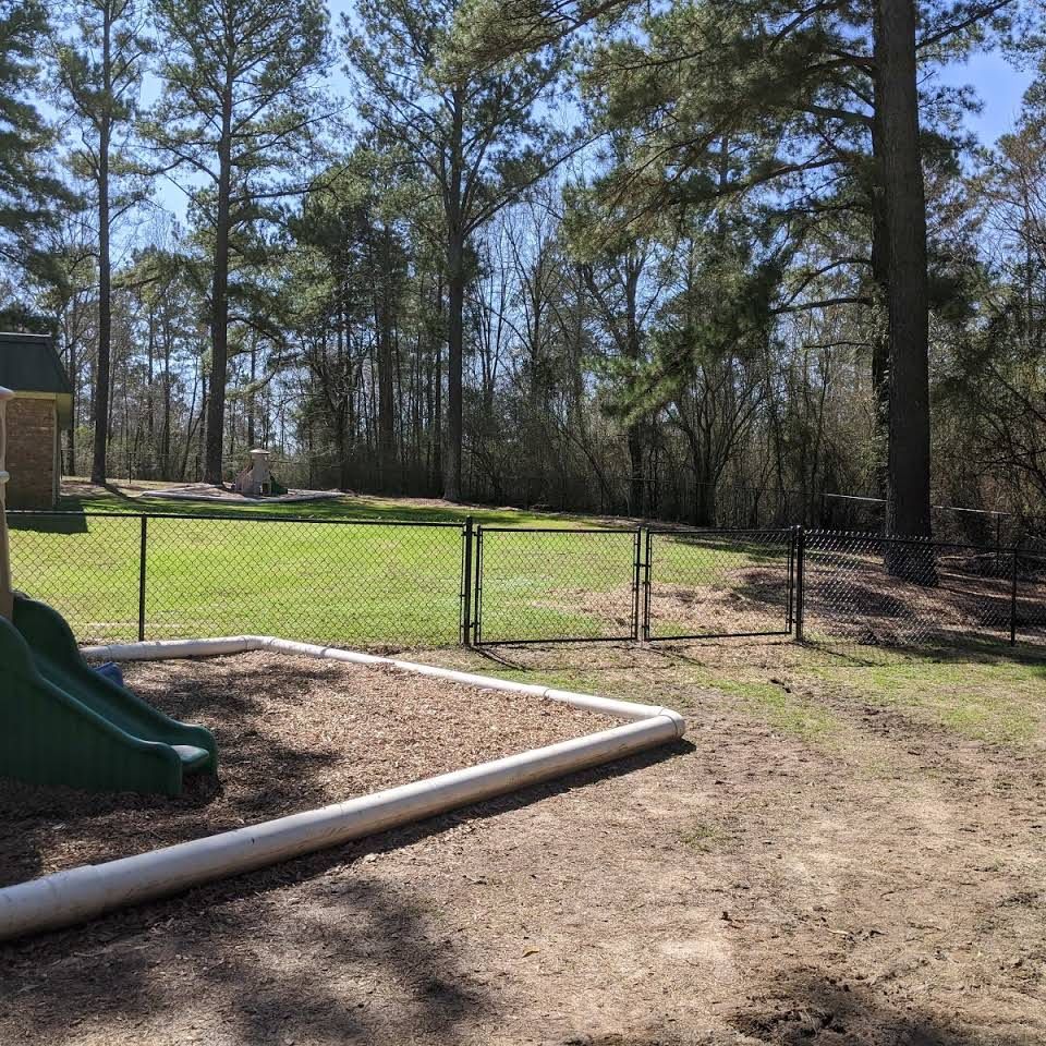 A playground with a slide and a fence in the background