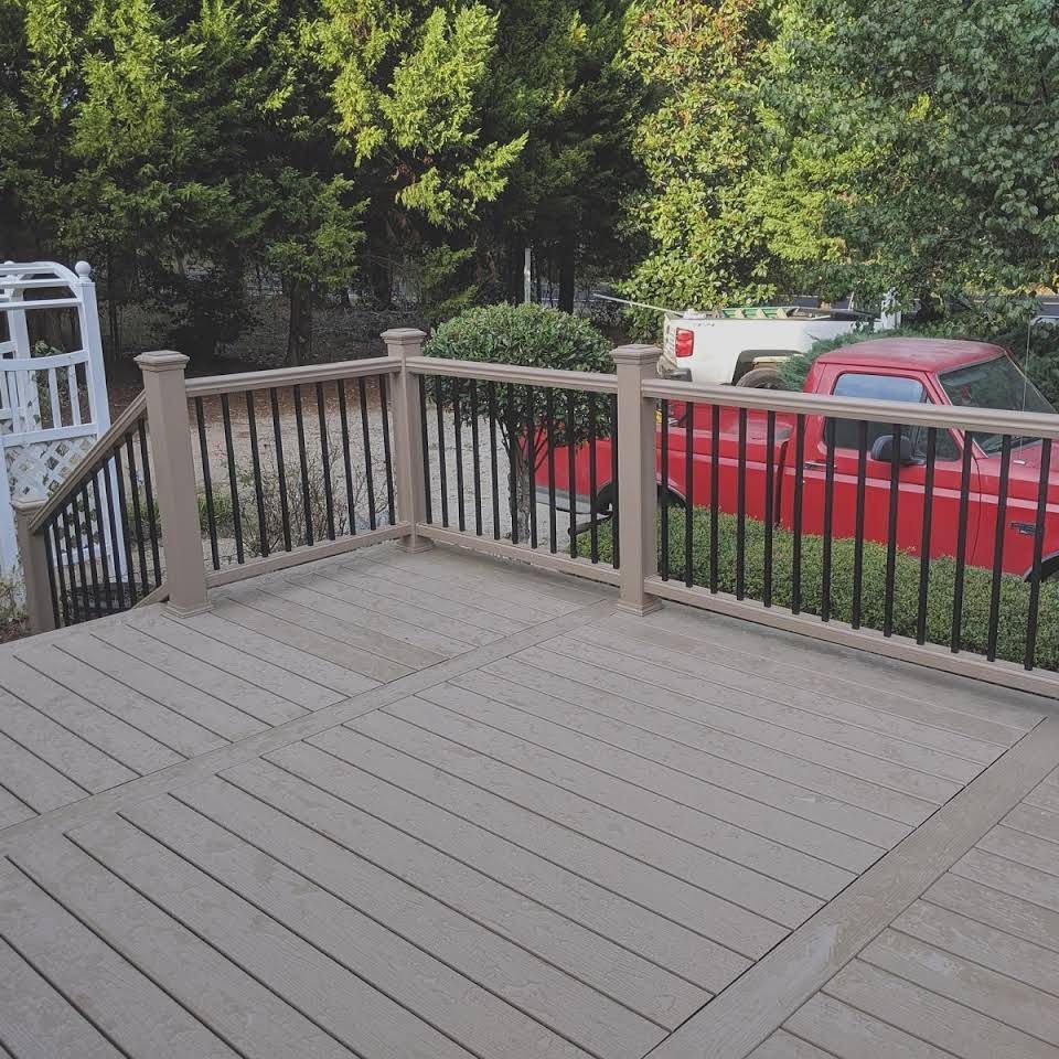 A deck with a railing and a red truck in the background