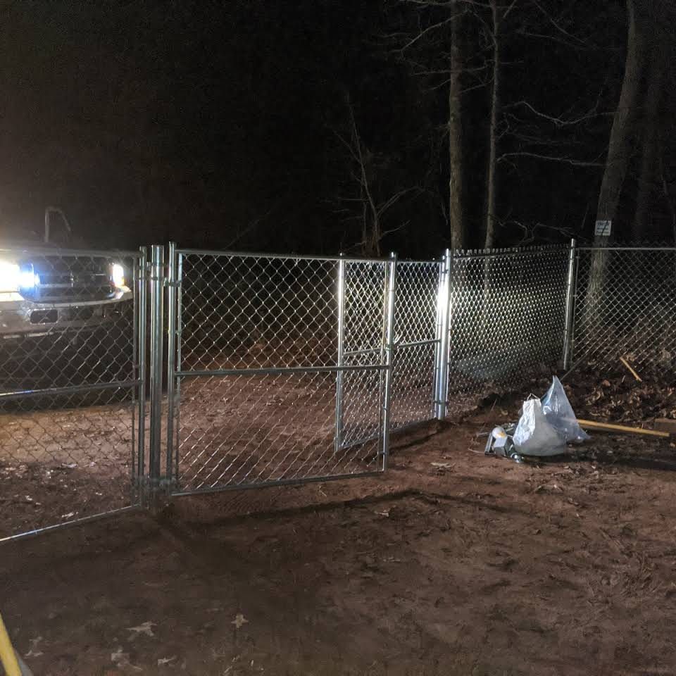 A chain link fence is lit up at night