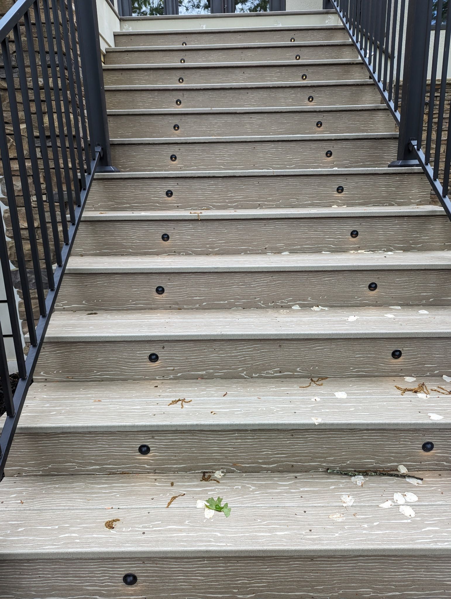 Wooden outdoor staircase with black metal railings.