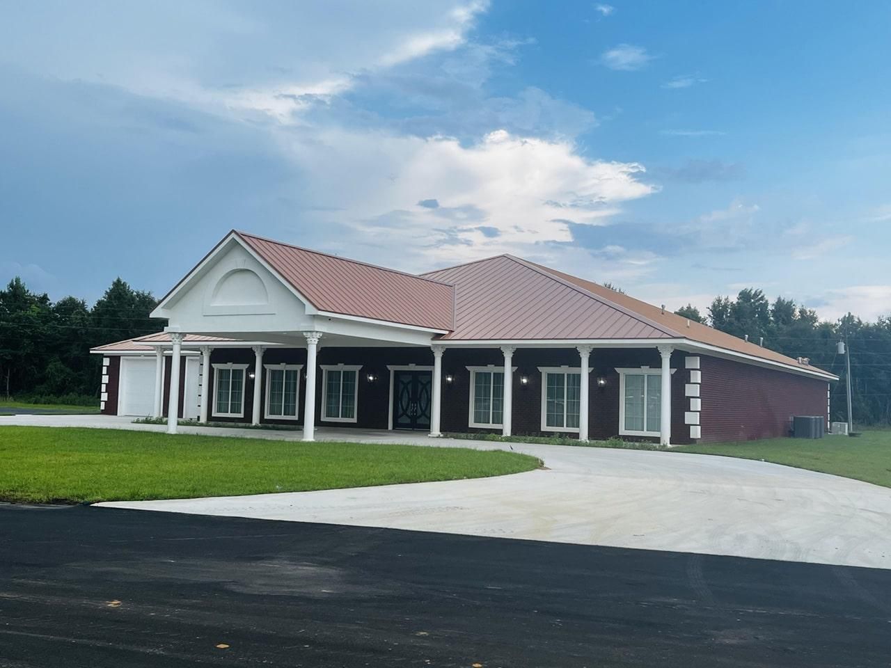 a large brick house with a red roof and white trim