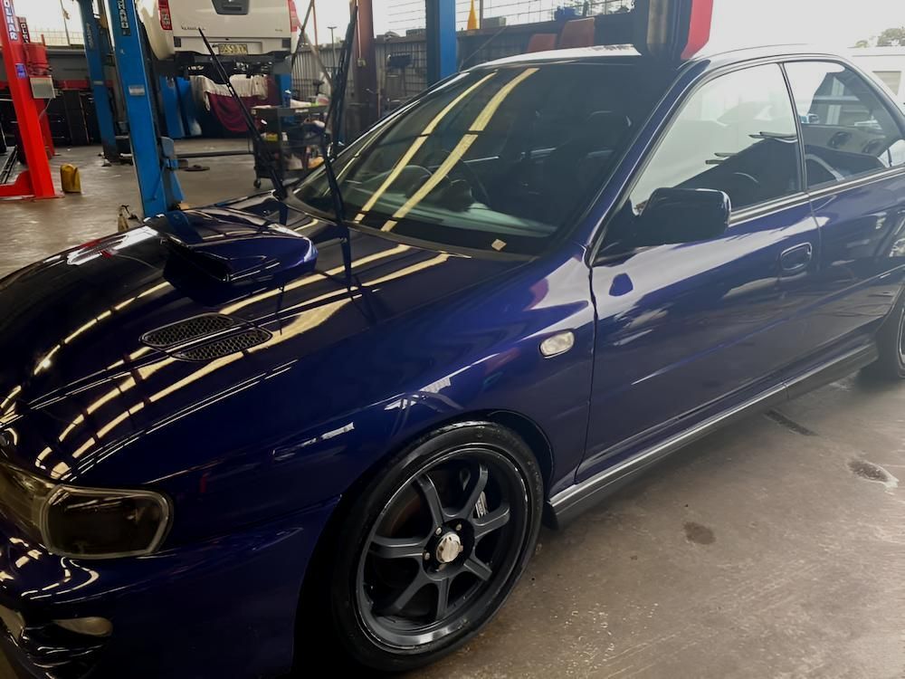 A Blue Car Is Parked In A Garage On A Lift — All Clean Auto Detailing In Caves Beach, NSW