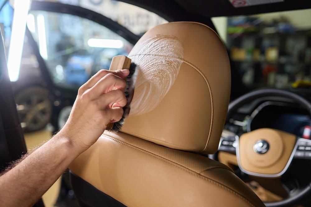 A Person Is Cleaning The Headrest Of A Car With A Brush — All Clean Auto Detailing In Summerland Point, NSW