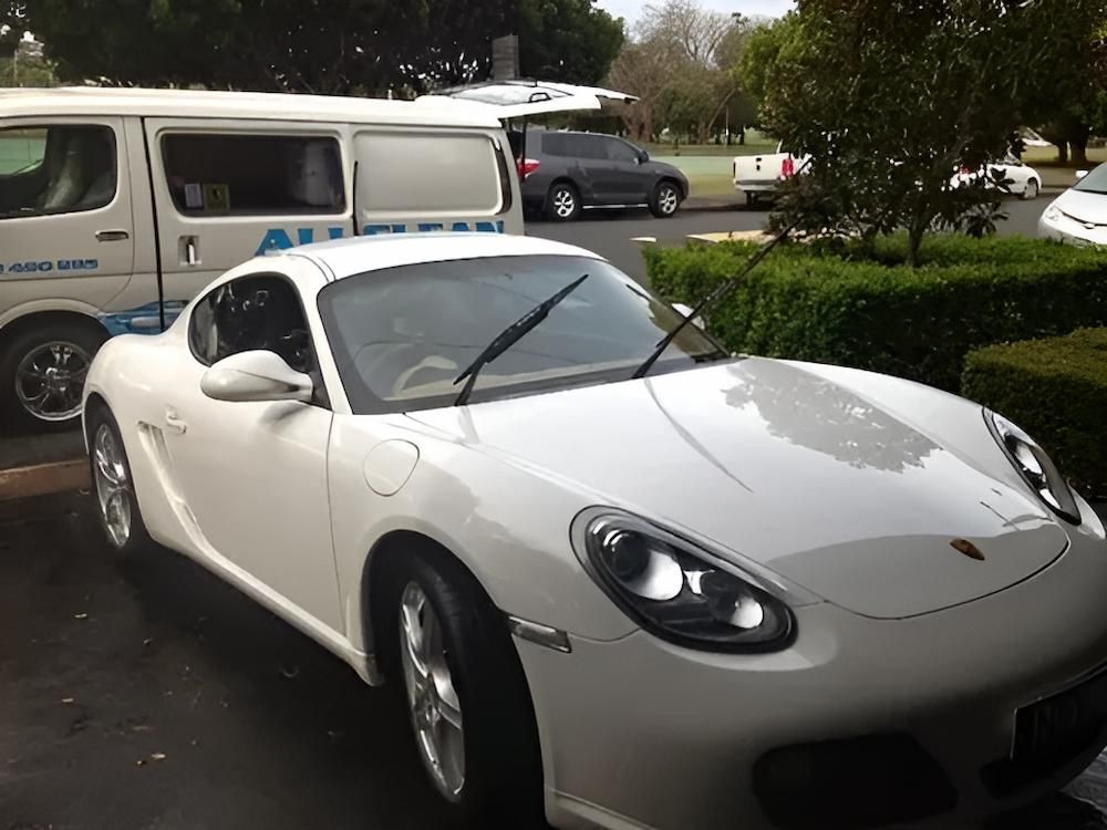 A White Sports Car Is Parked Next To A White Van — All Clean Auto Detailing In Caves Beach, NSW