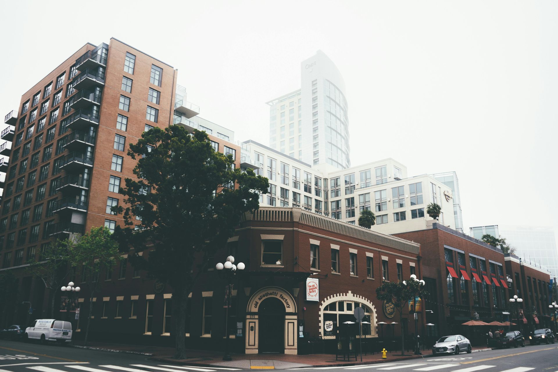 A brick building is on the corner of a city street.