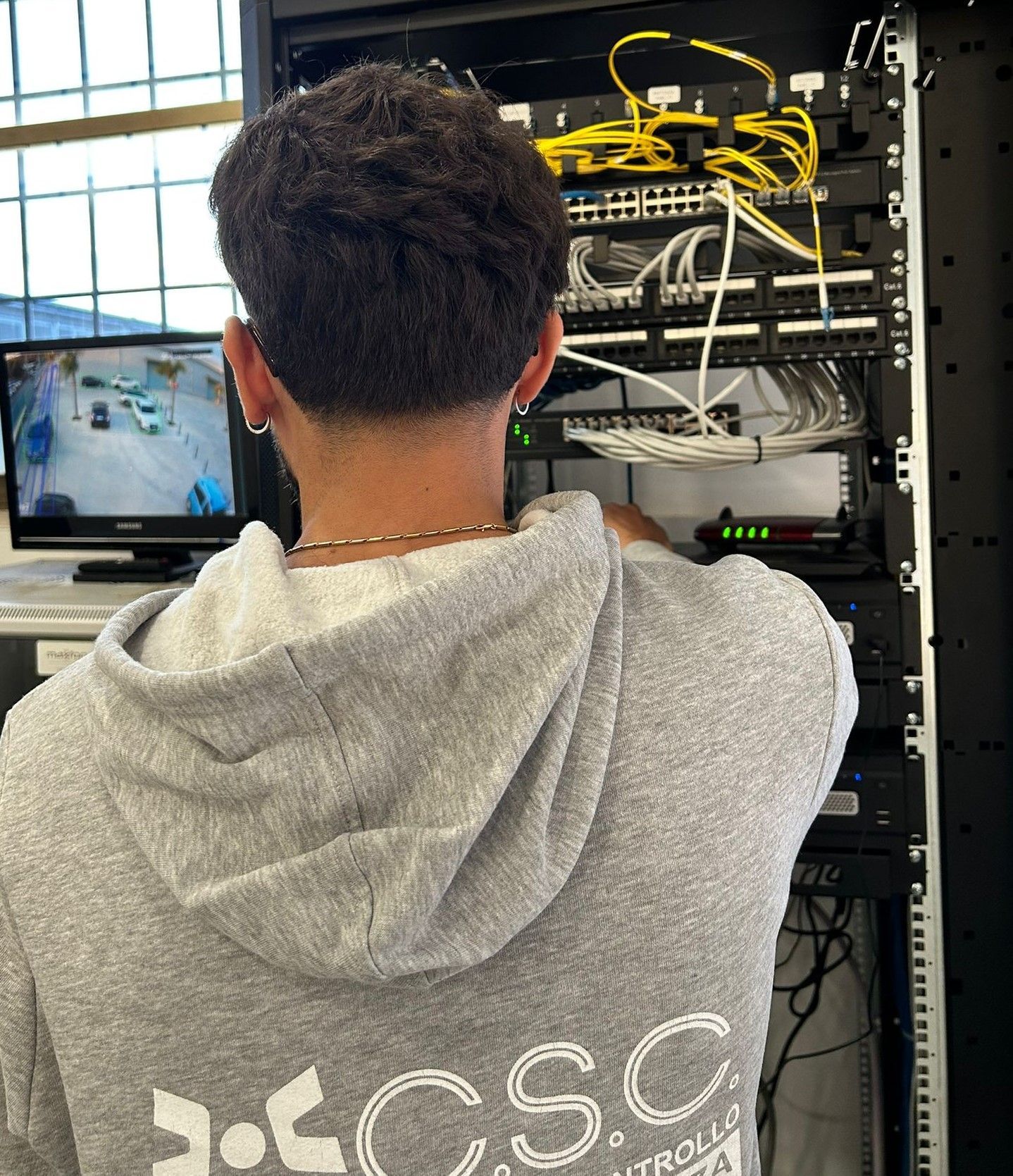 Un uomo che indossa una felpa con cappuccio che dice che csc sta lavorando su un server