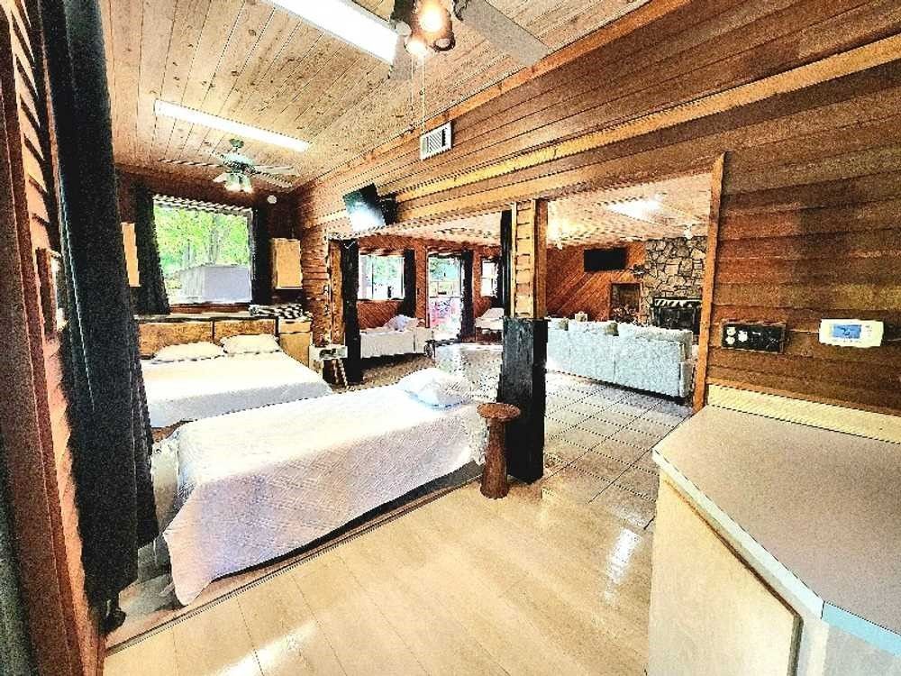 A large wooden cabin with three beds and a living room.