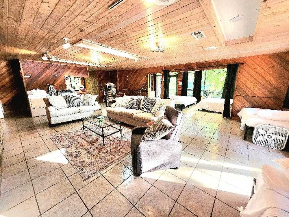 A living room filled with furniture and a wooden ceiling.