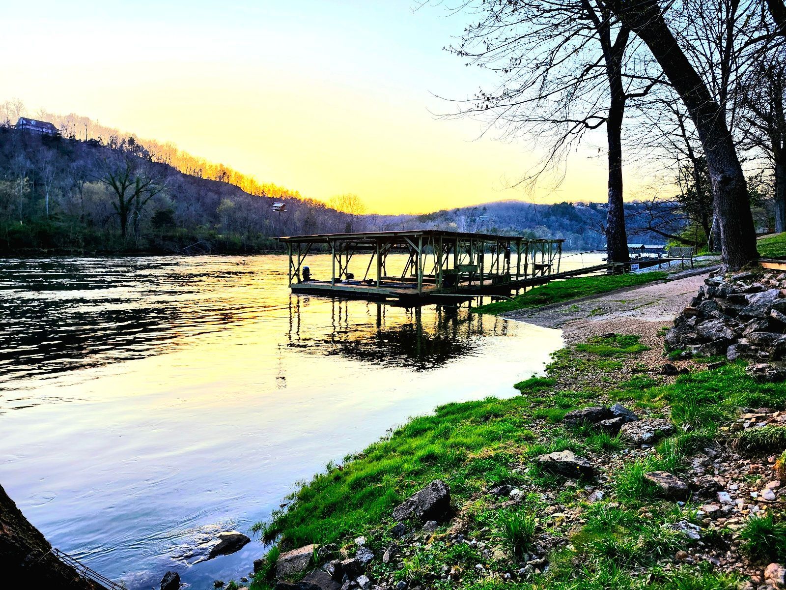 A dock is sitting on the shore of a river.