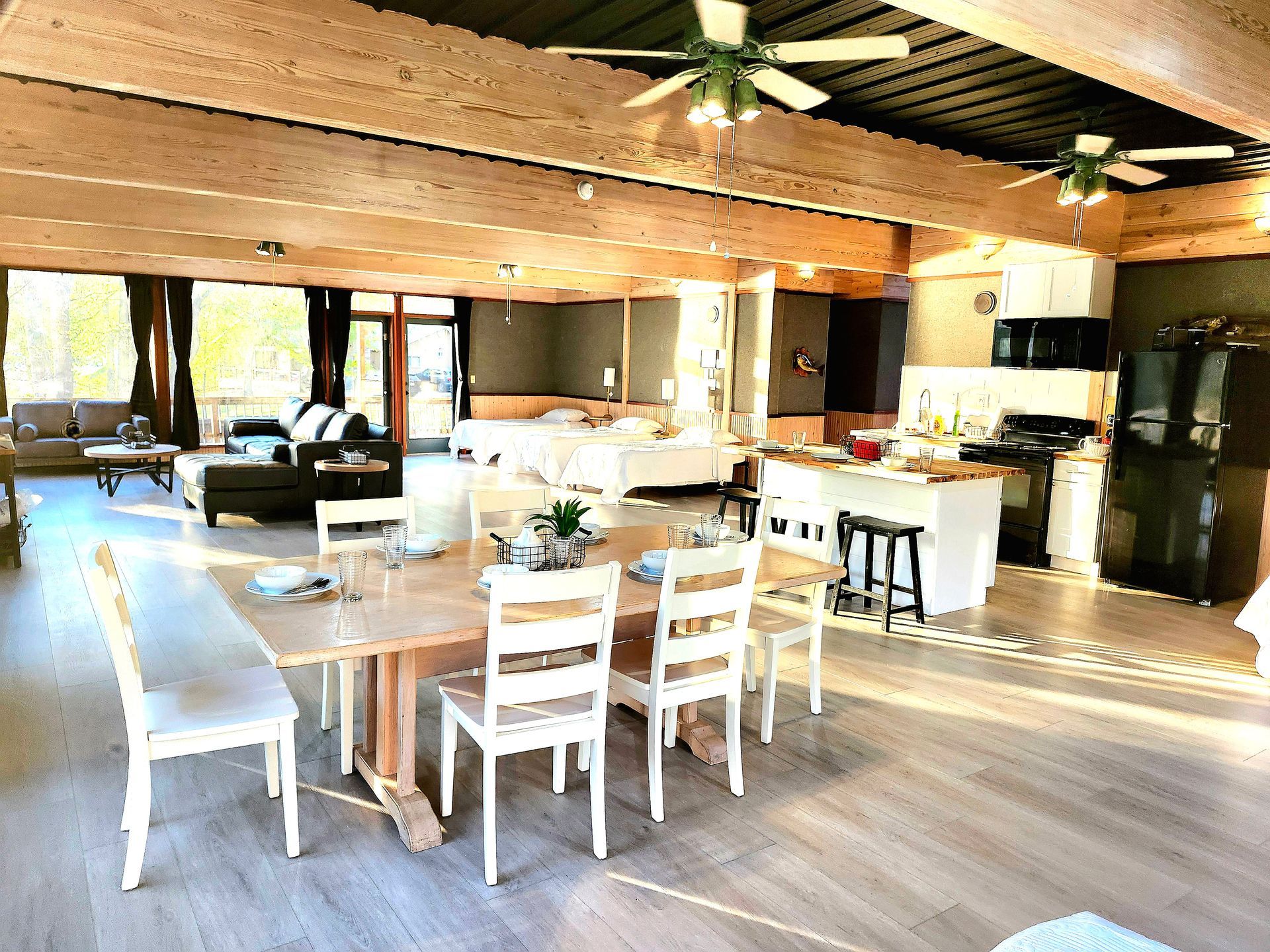 A large living room with a table and chairs and a ceiling fan.