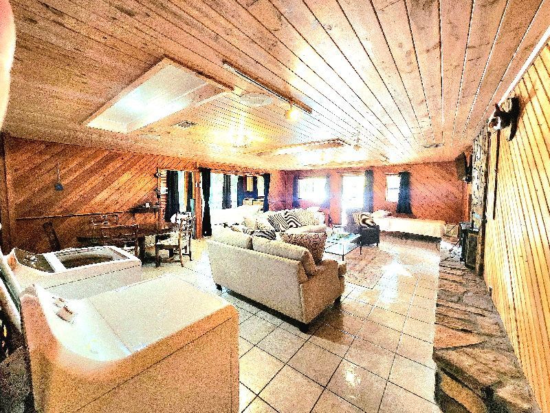 A living room with a couch , table , chairs and a washer and dryer.