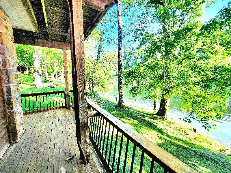 A porch with a view of a lake and trees.