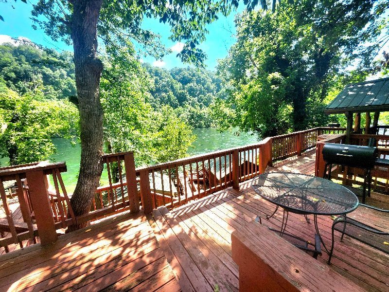 deck with table and smoker overlooking white river at copper johns resort