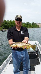 A man is standing on a boat holding a fish.